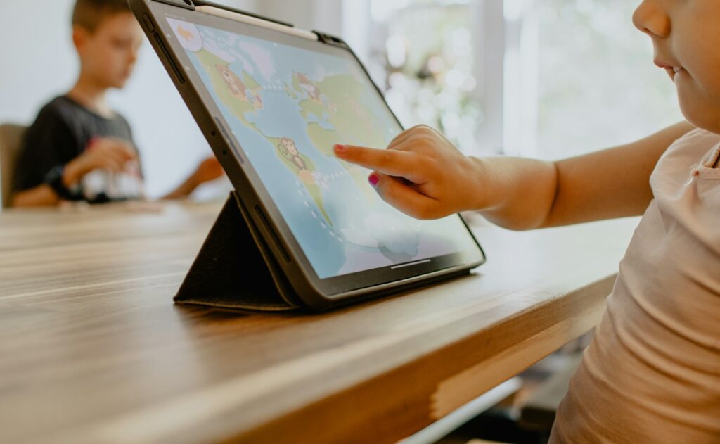 Child pointing at a map on a tablet