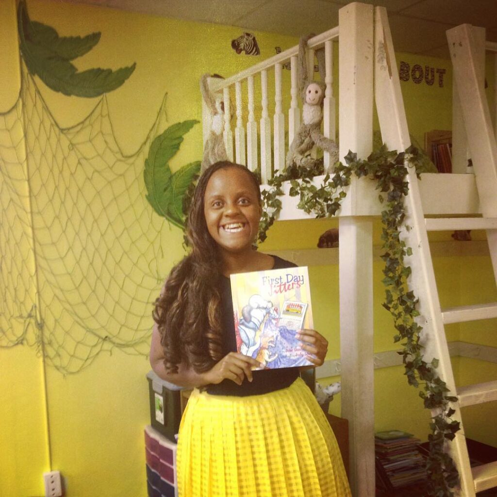 Vimbo Watson holding the book First Day Jitters in her classroom